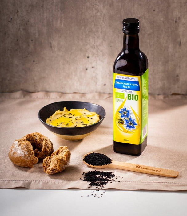 Flasche von Herbanordpol Bio Schwarzkümmelöl mit Etikett, das die biologische Herkunft und kaltgepresste Methode der Nigella sativa Samen zeigt