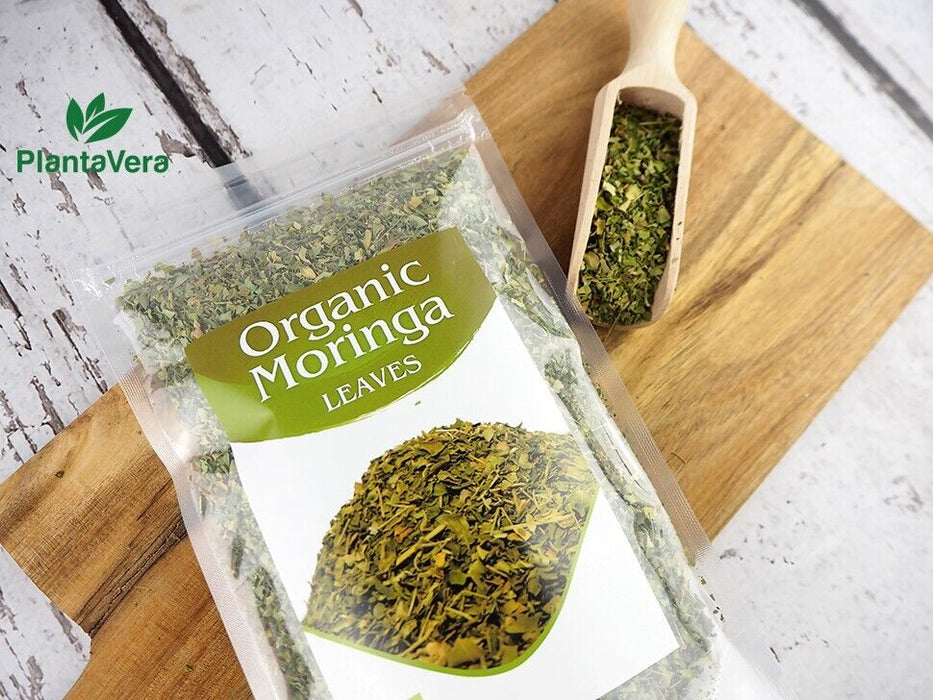 Organic Moringa Leaves Verpackung von PlantaVera mit Holzschaufel auf rustikalem Hintergrund
