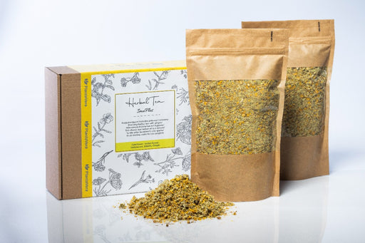 PlantaVera ImuFlos Kräutertee-Verpackung und braune Papiertüten voller Tee auf hellem Hintergrund, perfekt für Teeliebhaber.